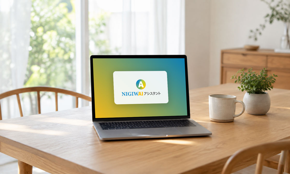 明るい自宅のテーブルに置かれた、NIGIWAIアシスタントを表示するノートパソコン